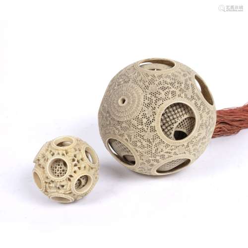 Canton carved ivory puzzle ball Chinese, 19th Century 10cm across and a smaller puzzle ball, 5.5cm