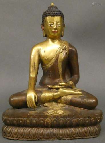 CHINA Bronze figure with brown and gold patina representing Buddha in lotus position on a lotiform base, trace of polychromy Size: 20,5cm