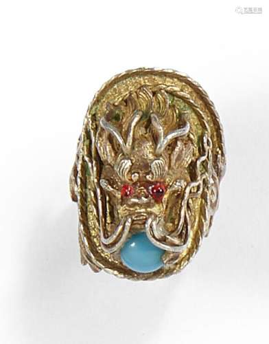 Gold-plated silver ring representing a dragon's head encircling a turquoise pearl in its mouth, the eyes enamelled red. L.: 2,5cm Net weight: 11,2g