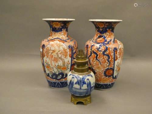 CHINA Pair of vases with Imari decoration. Ht: 31 cm A small blue and white porcelain lamp base is attached.