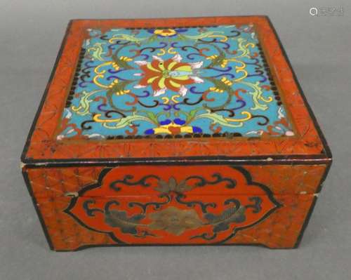 CHINA or JAPAN Wooden box decorated in red lacquer and on the lid covered with a cloisonné enamel decoration. Dim. 14 x 14 x 7,5cm