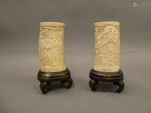 CHINA Set of two ivory brush holders carved with characters. Wooden bases.