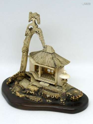 CHINA Bone sculpture depicting a house interior with characters. Wooden base Ht: 16cm