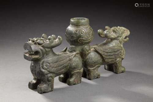 CHINA Sculpture in green jade representing two fantastic animals back to back supporting a central urn. Acting as a torchbearer in the archaic style. Modern period L.: 31 cm