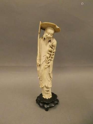 CHINA Carved ivory statuette of a man with a hat. Circa 1930. H. : 27 cm