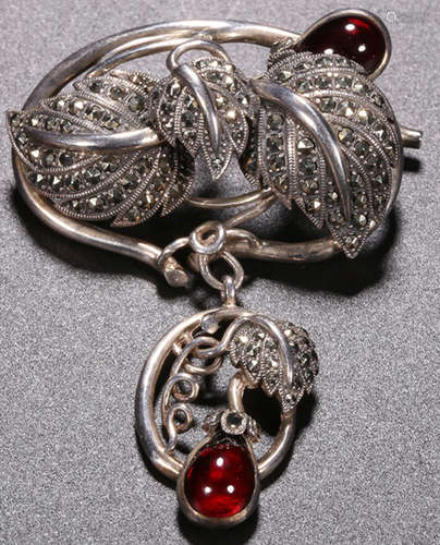 A SILVER AND GARNET BROOCH