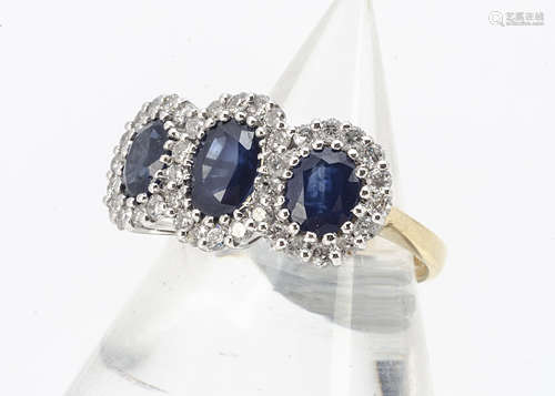 A triple cluster sapphire and diamond dress ring, set in white gold claw settings on a yellow