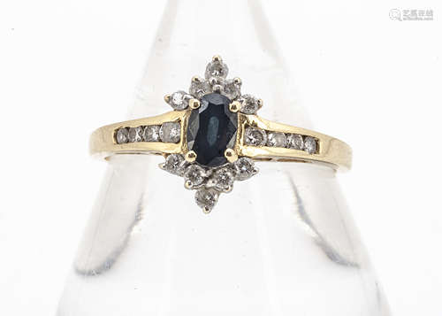 An 18ct gold sapphire and diamond cluster ring, the oval mixed cut claw set sapphire surrounded by