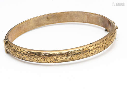 A 9ct gold hollow hinged bangle, oval shape with engraved floral decoration, interior measurements