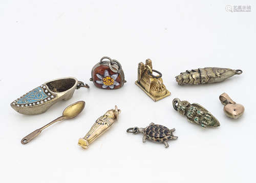 A miscellaneous collection of gold and silver charms, including a seed pearl and blue enamel heart