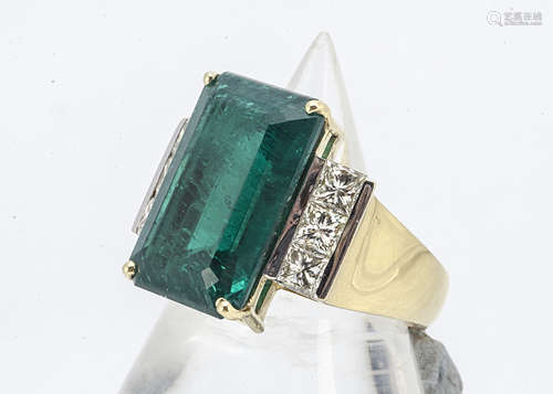 An Art Deco style diamond and synthetic emerald dress ring, the central claw set emerald cut stone