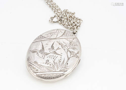 A Victorian silver Aesthetic style oval locket, decorated with a pair of swallows within a landscape