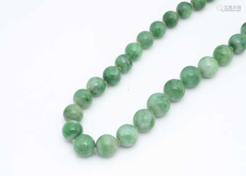 A string of jadeite jade graduated beads, the knotted strung necklace 38cm together having no clasp,