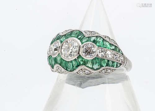 An Edwardian style emerald and diamond platinum dress ring, the three old cuts surrounded in a