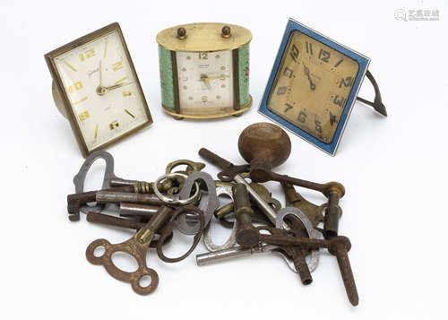 An Art Deco enamelled travel timepiece, AF, together with two further travel clocks and an OXO tin