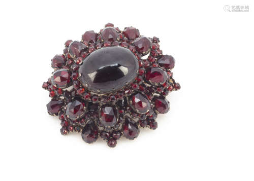 A Bohemian garnet foil back oval brooch, with central oval cabochon in claw settings surrounded by a