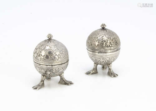 A pair of late 19th Century Indian white metal pepper pots, spherical with half dome covers and with