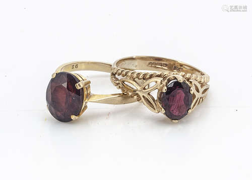 Two 9ct gold garnet dress rings, each set with oval mixed cut garnets in claw settings, one in