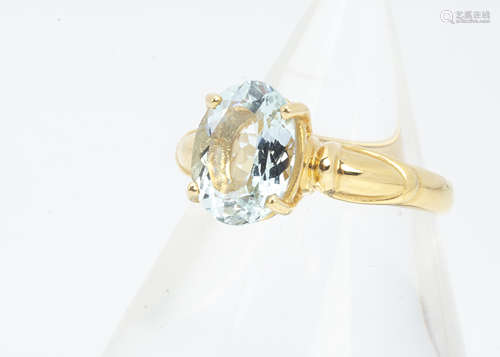 An 18ct gold aquamarine dress ring, the oval cut aquamarine in four claw setting on a gold shank,