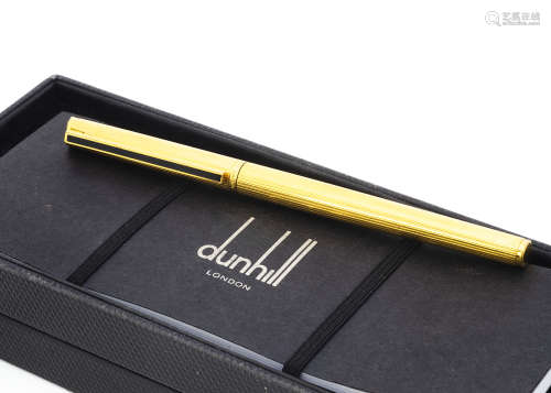 A Dunhill roller ball pen, gilt with black panel to clip, in box