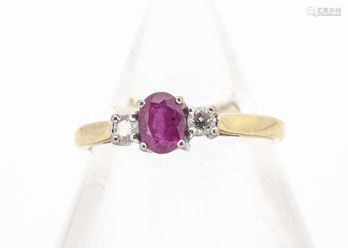 An 18ct gold ruby and diamond three stone ring, the white claw set mixed cut oval flanked by a