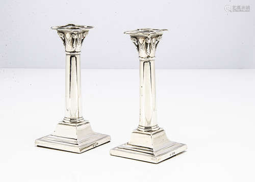 A pair of George V silver filled candlesticks by Thomas Bradbury & Sons, square bases with