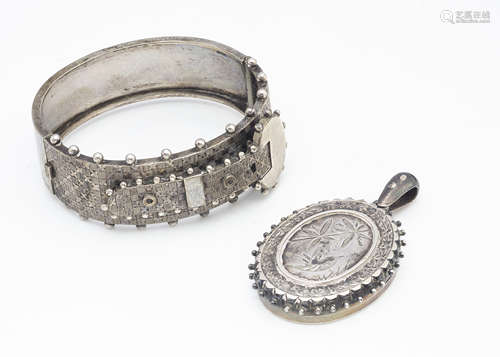 An articulated Edwardian white metal bangle, of buckle design together with a Victorian silver