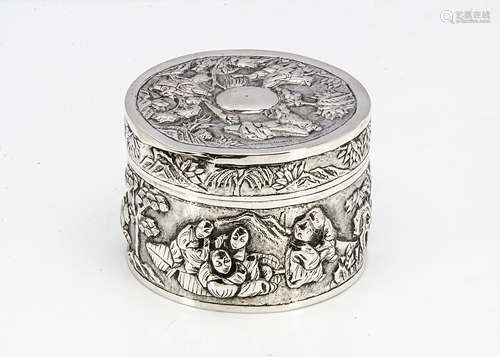 An early 20th Century Chinese white metal circular box, with raised scenes of figures, marked to