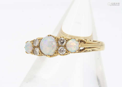 An 18ct gold opal and diamond dress ring, the three cabochon opals alternately set with pairs of