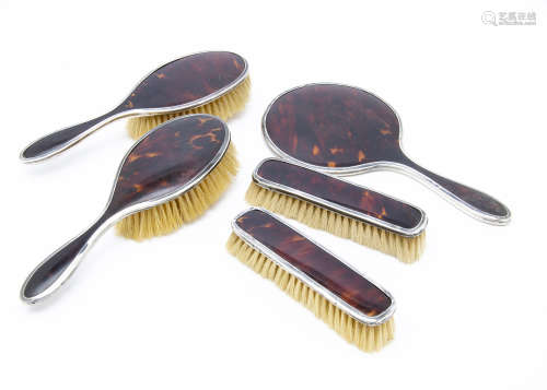 A George V silver and tortoiseshell five piece dressing table set by Adie Bros
