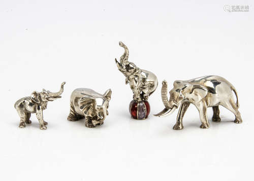 Four small modern silver figures of elephants, one balancing on an enamelled ball, 4.4cm, one larger