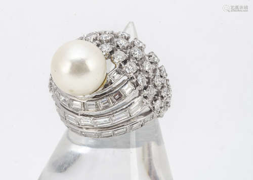 A 14ct white gold diamond and pearl bombe shaped dress ring, the cultured pearl upon an oval setting