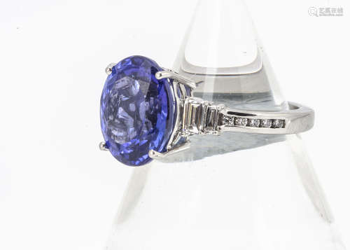 A platinum tanzanite and diamond contemporary dress ring, the oval mixed cut tanzanite in four