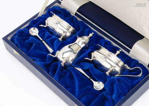 A modern silver cased cruet set, the salt and mustard having blue glass liners, with a pepper and