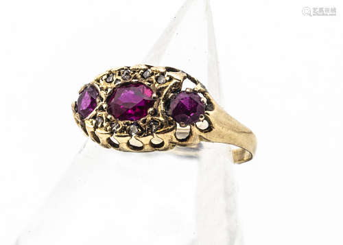 An Edwardian ruby and diamond dress ring, the three mixed cut rubies, in an oval shaped setting