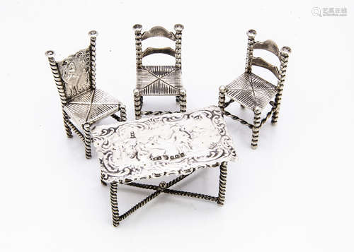 A late Victorian continental silver miniature dining table and pair of chairs by JBL, the table