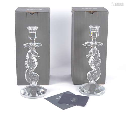 Two Waterford crystal candlesticks, the bowls raised and supported by figural seahorses, in original