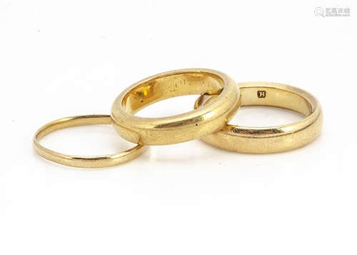 A 22ct gold court shaped wedding band, ring size I, another example ring size K 1/2, and a thin band