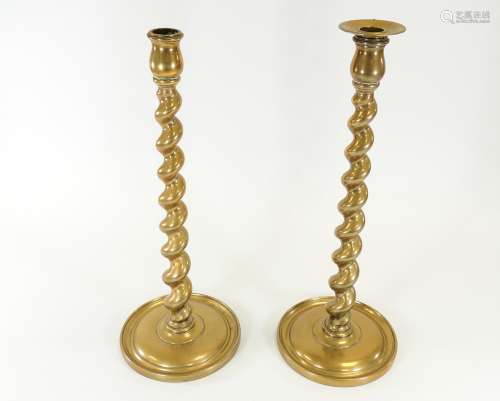 A pair of brass barley twist candlestick holders, the bases with impressed registration numbers,