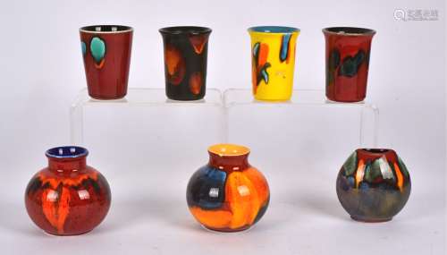 Seven pieces of Poole Pottery, to include four beaker shaped vases, height 9.5cm, two bulbous