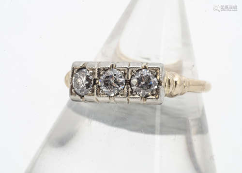 A three stone diamond ring, the old cut diamonds in square illusion settings, on yellow metal shank,