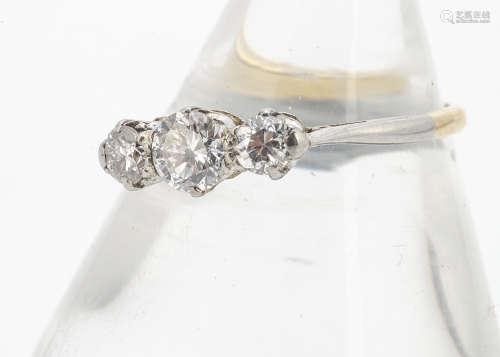 An 18ct gold and platinum set three stone diamond ring, the brilliant cuts in claw setting on a