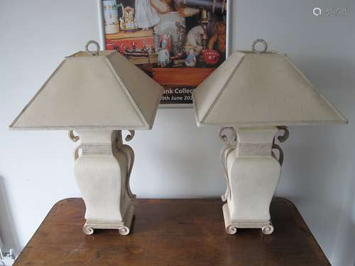 A pair of contemporary ceramic table lamps, simulated stone effect with scroll feet and handles,