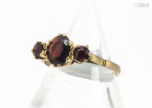 A three stone 9ct gold garnet dress ring, ring size R, 2.1g