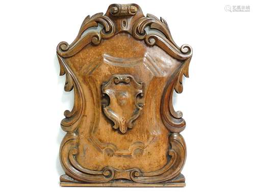 A mahogany armorial style plaque, with scrolling edges and wire for hanging, 49cm x 34cm