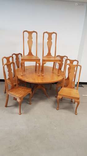 A contemporary oak circular pedestal table and eight matching dining chairs by Alan Solly of