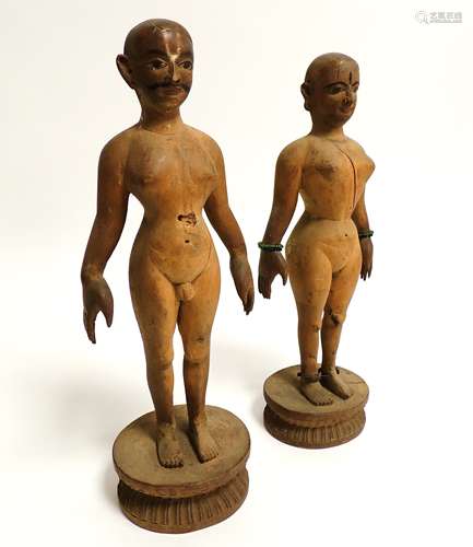 A pair of South Asian softwood figures, being nude male and female raised on a lotus base, the