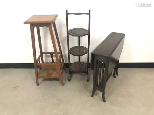 Three pieces of furniture, including an Arts & Crafts plant stand, a later folding cake stand and