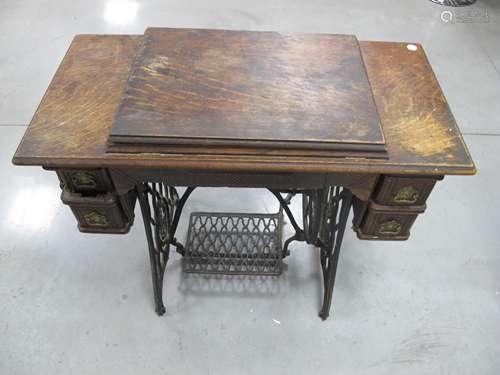 A vintage American Singer treadle sewing machine, housed in kneehole oak case with two short drawers