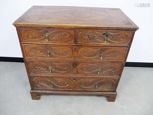 An 18th Century oak chest, of two short over three long graduated drawers, later carving to panelled